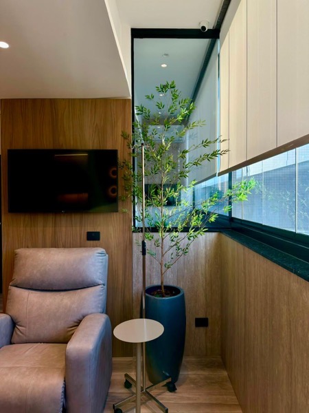 Sala reservada com poltrona reclinável e oliveira